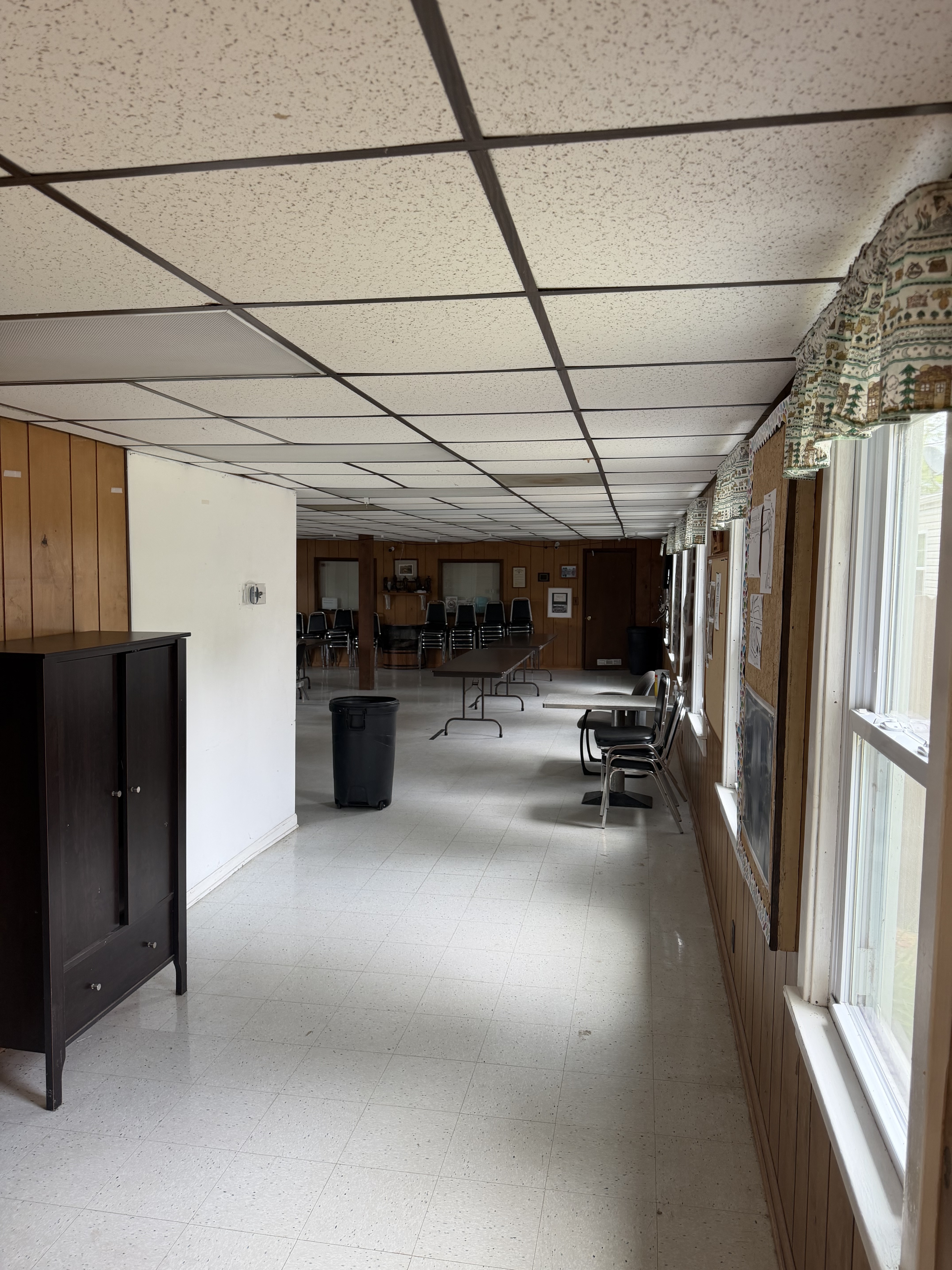 Main hall of the Deer Creek Recreation Club clubhouse looking toward the meeting room with wood paneling and bulletin boards