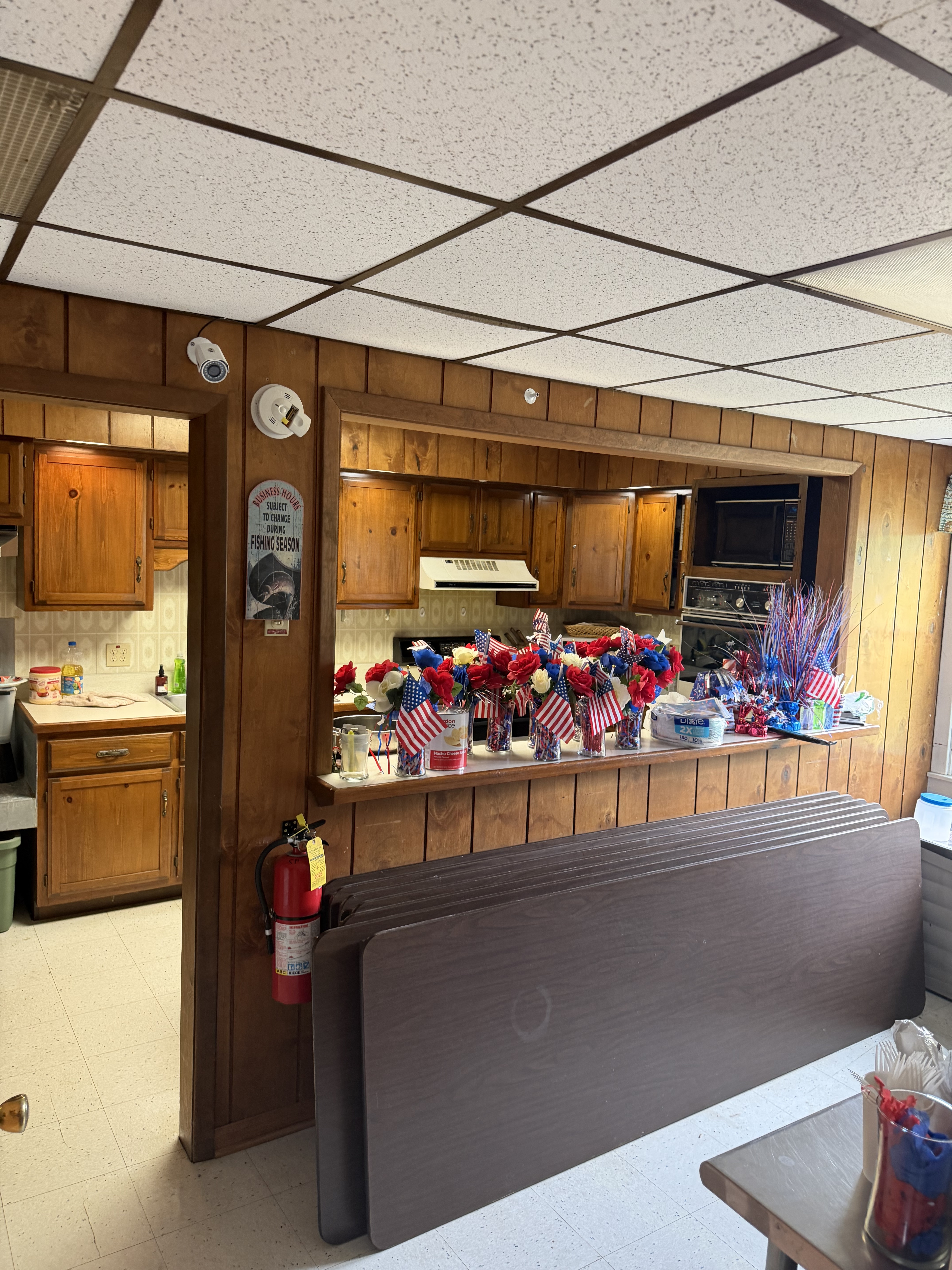 Deer Creek Recreation Club clubhouse kitchen pass-through window decorated for Fourth of July with patriotic floral arrangements