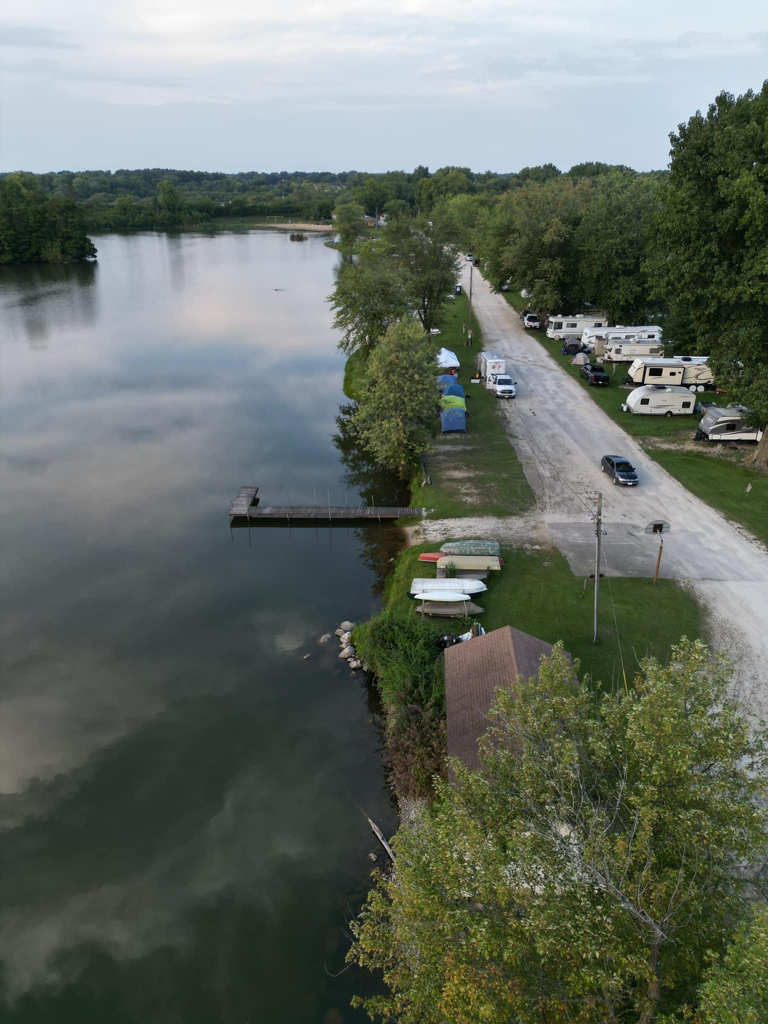 Aerial drone view of Deer Creek Lake shoreline showing lakeside campsites tents RVs and boat dock in Plainfield Illinois