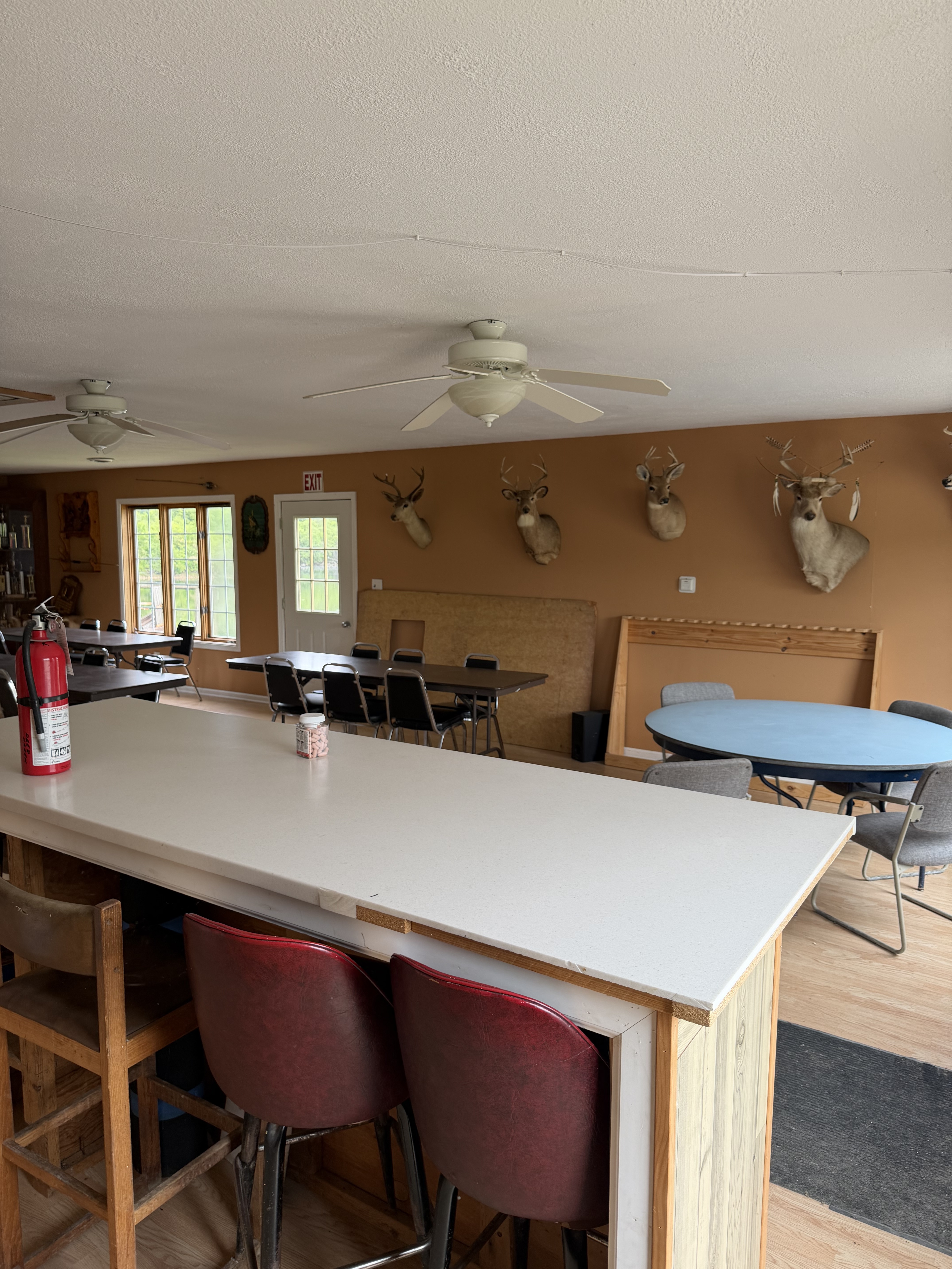 Deer Creek Recreation Club Trap House interior with bar area, deer trophy mounts, and hunter gathering space
